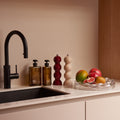 Geschenkbox Kitchen Stories van Collections by Gaav Interieur op het aanrecht: Addison Ross Bobbin peper- en zoutmolens, Ajen Hand Wash en Balm en Blister Bowl fruitschaal met fruit