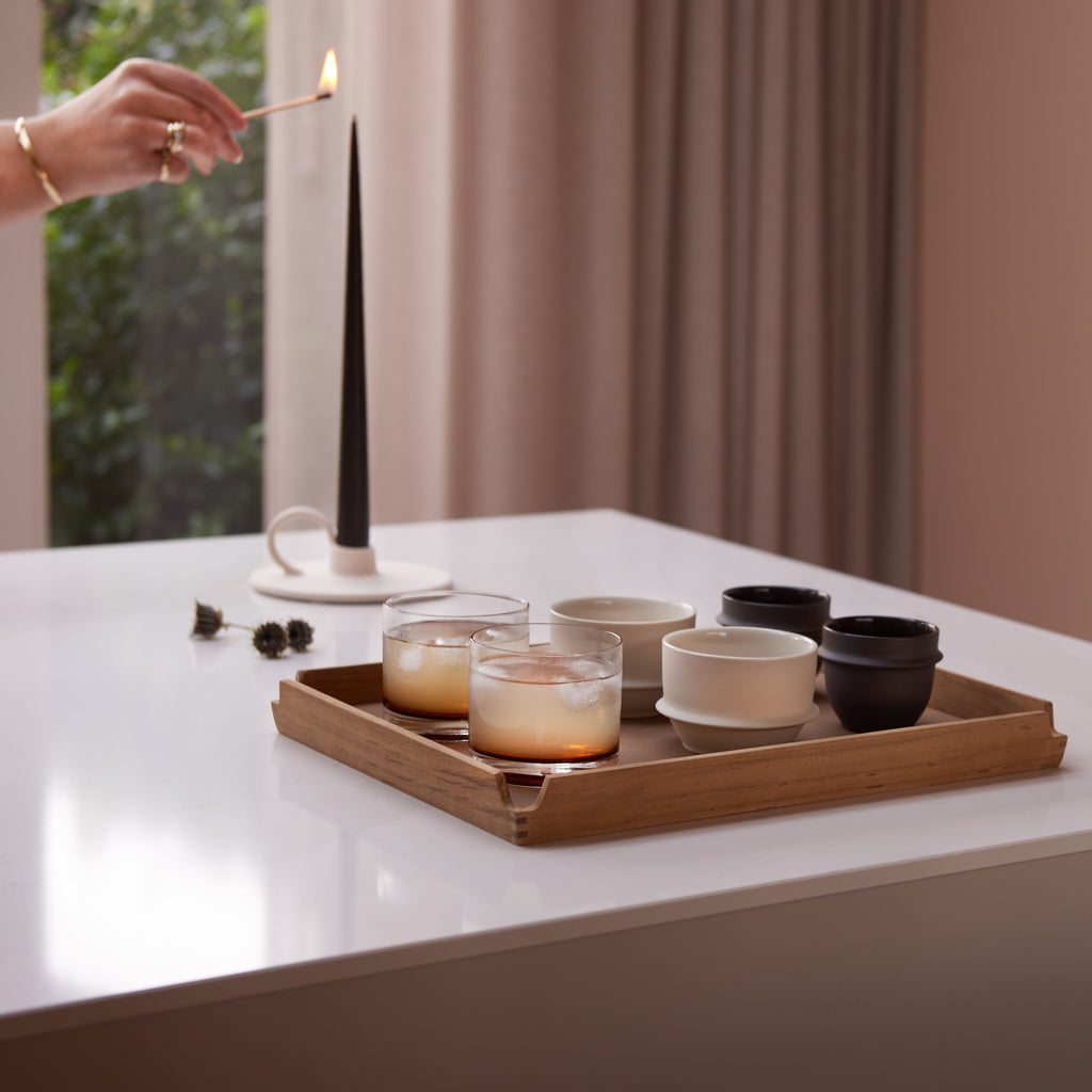 Geschenkbox Morning Ritual van Collections by Gaav Interieur: LIND DNA teak dienblad met Serax Dune koffiekopjes en Zuma glazen, en een espresso taper kaars in de Mira kandelaar