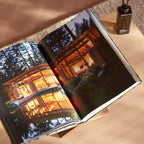 Geschenkbox Welcome Home van Collections by Gaav Interieur: TASCHEN Homes for Our Time opengeslagen op de handgemaakte eikenhouten boekenstandaard, met Ajen Wilderloof geurstokjes