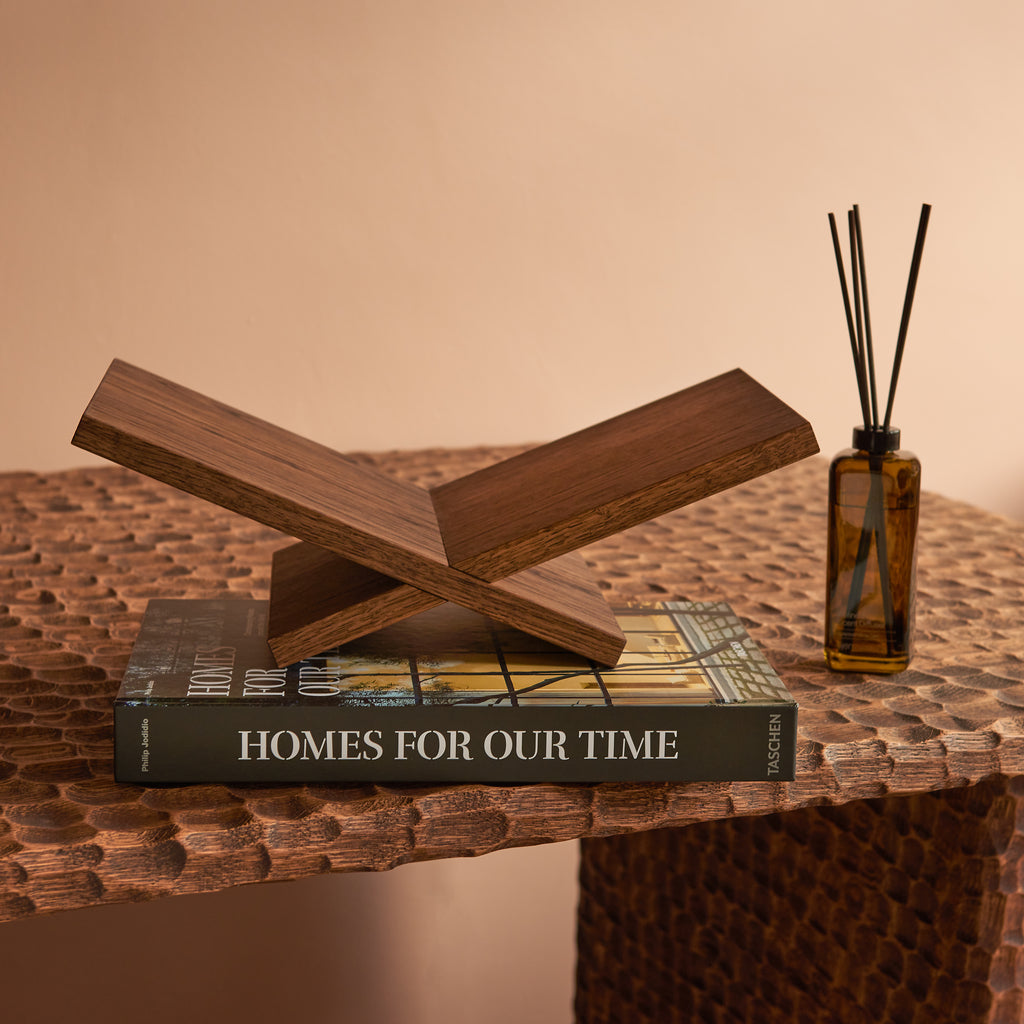 Geschenkbox Welcome Home: handgemaakte eikenhouten boekenstandaard van Gaav Interieur op het TASCHEN boek Homes for Our Time, naast Ajen Wilderloof geurstokjes
