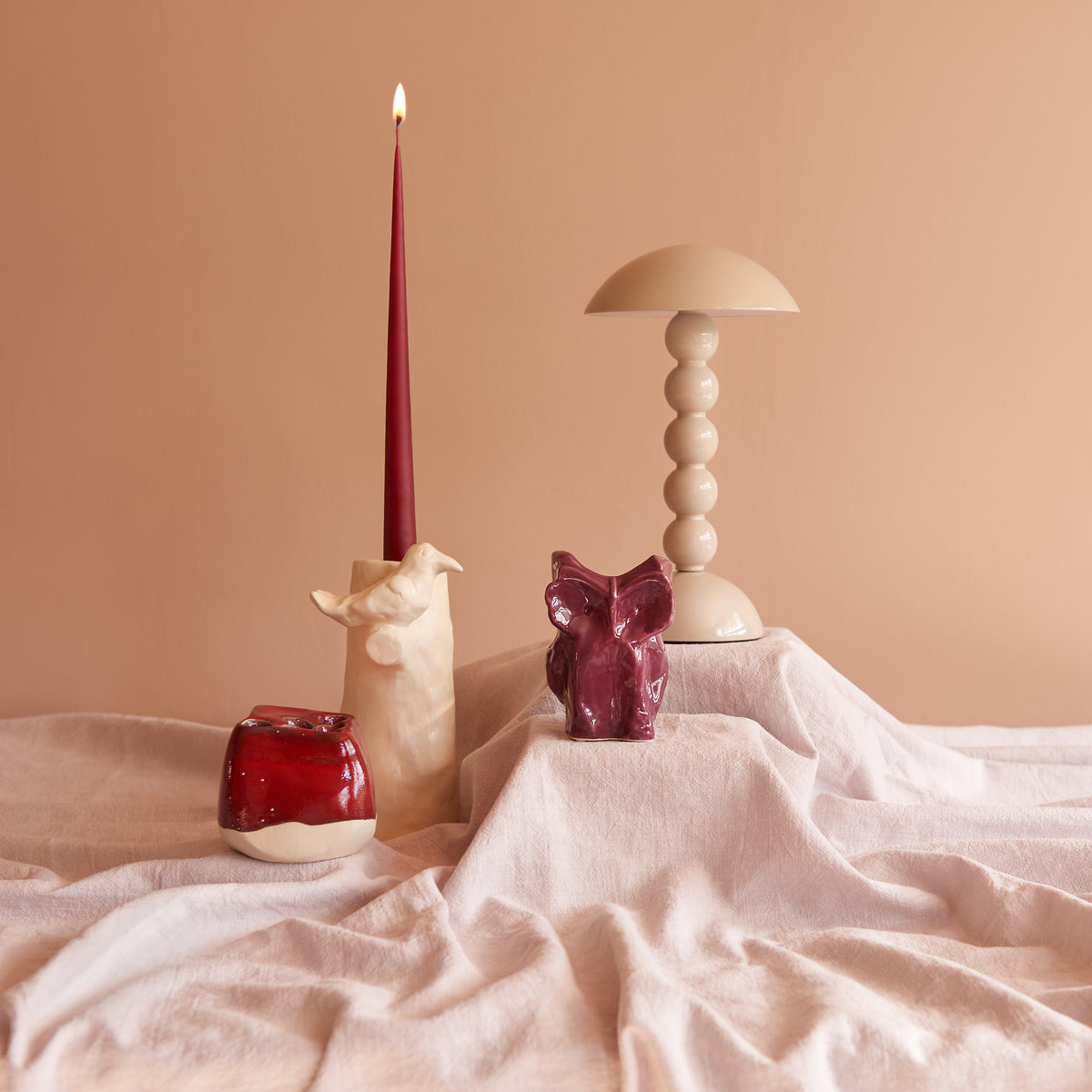 Inhoud geschenkbox Amazing Cabinet: Addison Ross Bobbin tafellamp, Serax Owl vaas in aubergine, rode Pique-Fleurs vaas en Cosas Lindas kandelaar met wijnrode taper kaars