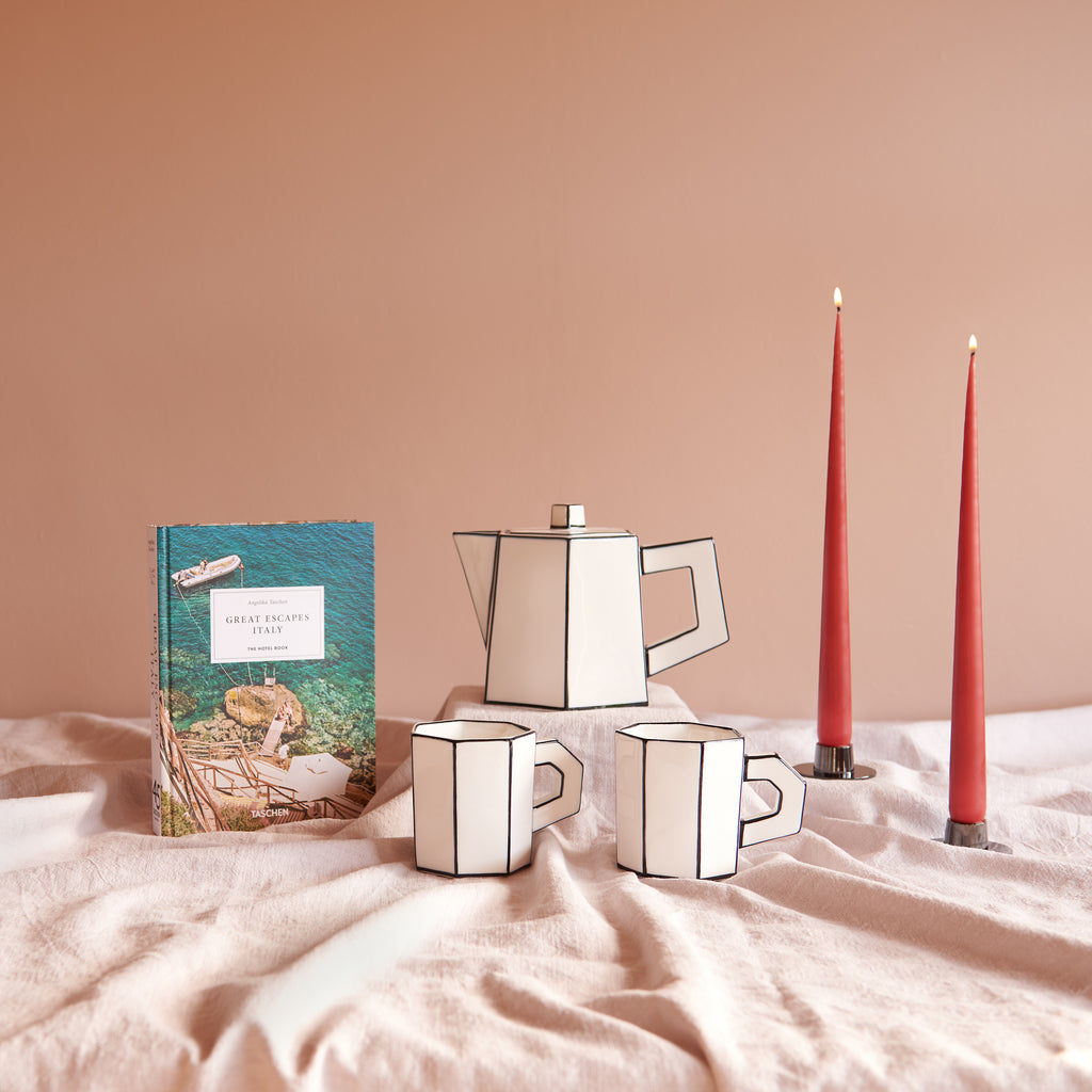 Inhoud geschenkbox Slow Living: TASCHEN Great Escapes Italy, Serax Carte Blanche theepot en twee theekopjes en Ester & Erik taper kaarsen in Aged Rust met zwarte kaarshouders